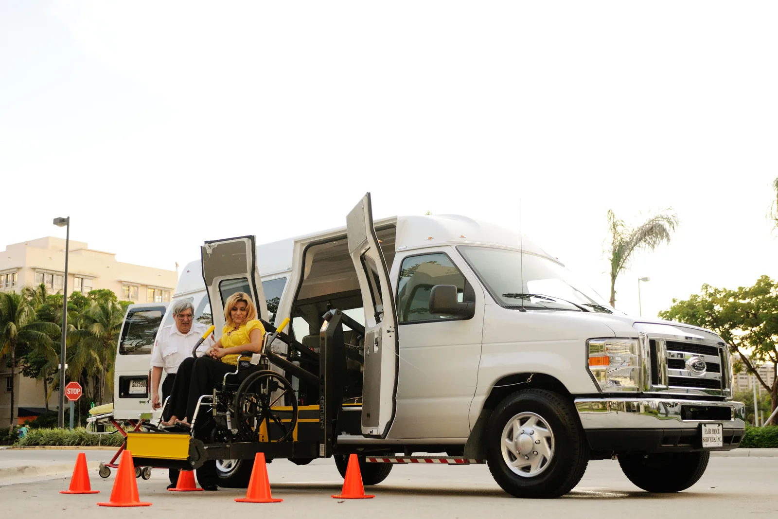 A woman in a wheelchair uses a lift to board an accessibility van assisted by a driver. A camera on a wheelchair accessible trip: what it has to prove
