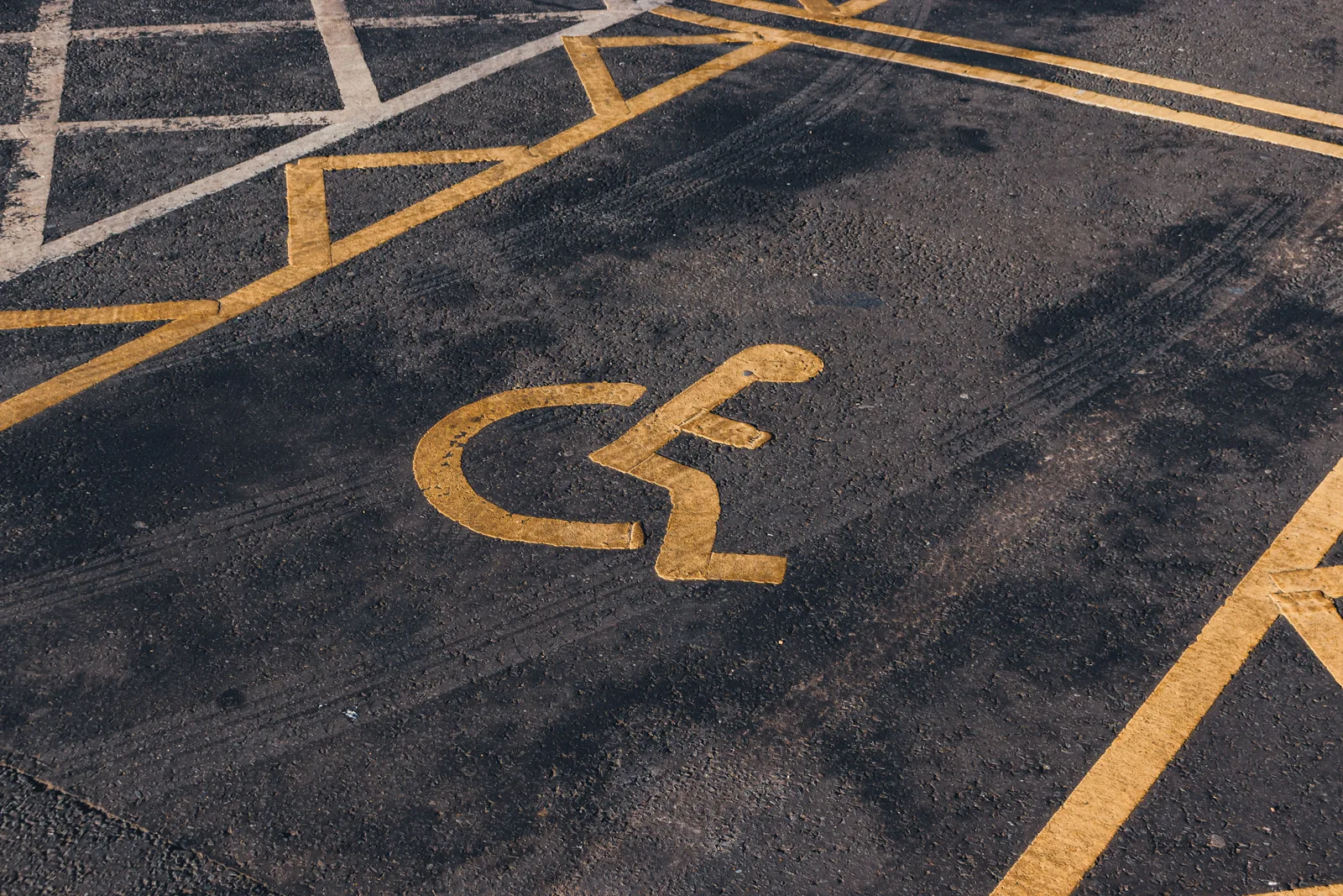 Close-up view of an international accessibility symbol painted on a parking lot surface. Accessible US Travel Businesses: What to Measure