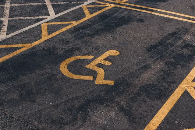 Close-up view of an international accessibility symbol painted on a parking lot surface. Accessible US Travel Businesses: What to Measure