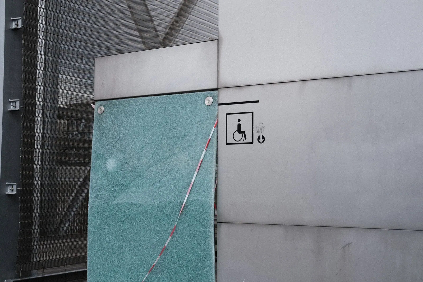 Urban architectural facade featuring an accessibility symbol for wheelchair access.