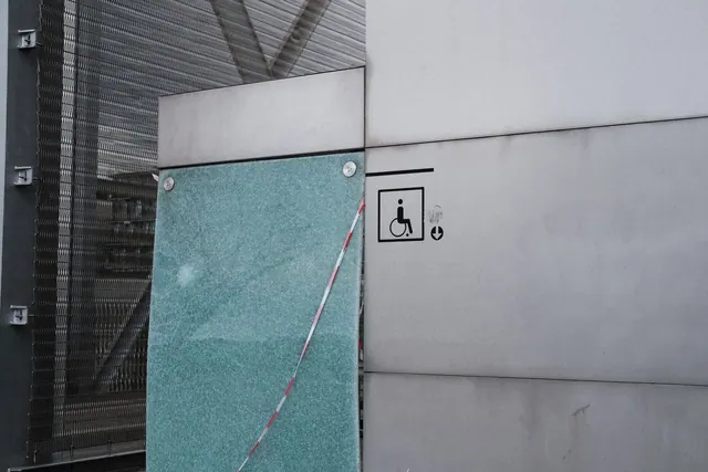 Urban architectural facade featuring an accessibility symbol for wheelchair access.