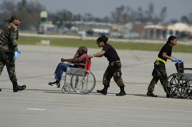 New Orleans, LA, 9/4/05 -- An evacuee being pushed in a wheel chair at the New Orleans Airport which is being used as a stageing area to send people to shelters around the country. New Orleans is being evacuated because of flooding caused by hurricane Katrina. Photo by: Liz Roll. How to Request Wheelchair Assistance at a U.S. Airport