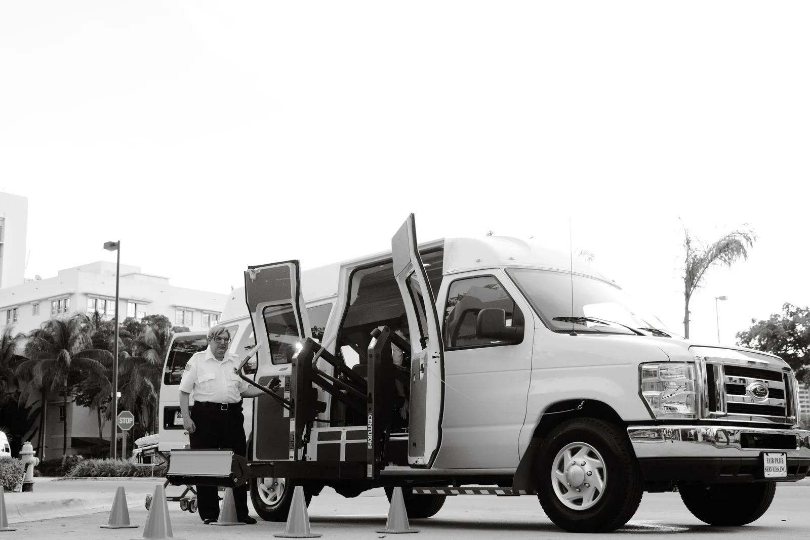 A black and white image depicting an accessible transport van with a lift, enhancing mobility for passengers with disabilities. Wheelchair accessible trips cost: what to budget for