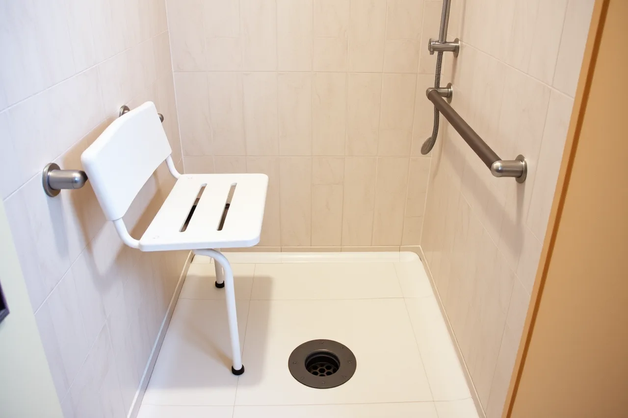 Curbless roll-in shower with wall-mounted folding seat and grab bar (What one traveler's booking near-miss teaches about accessible trips)